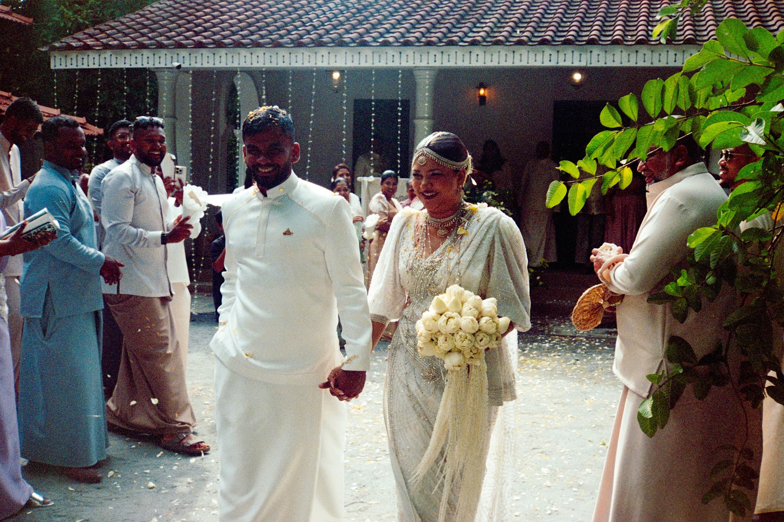 A bride and groom walking through the courtyard
