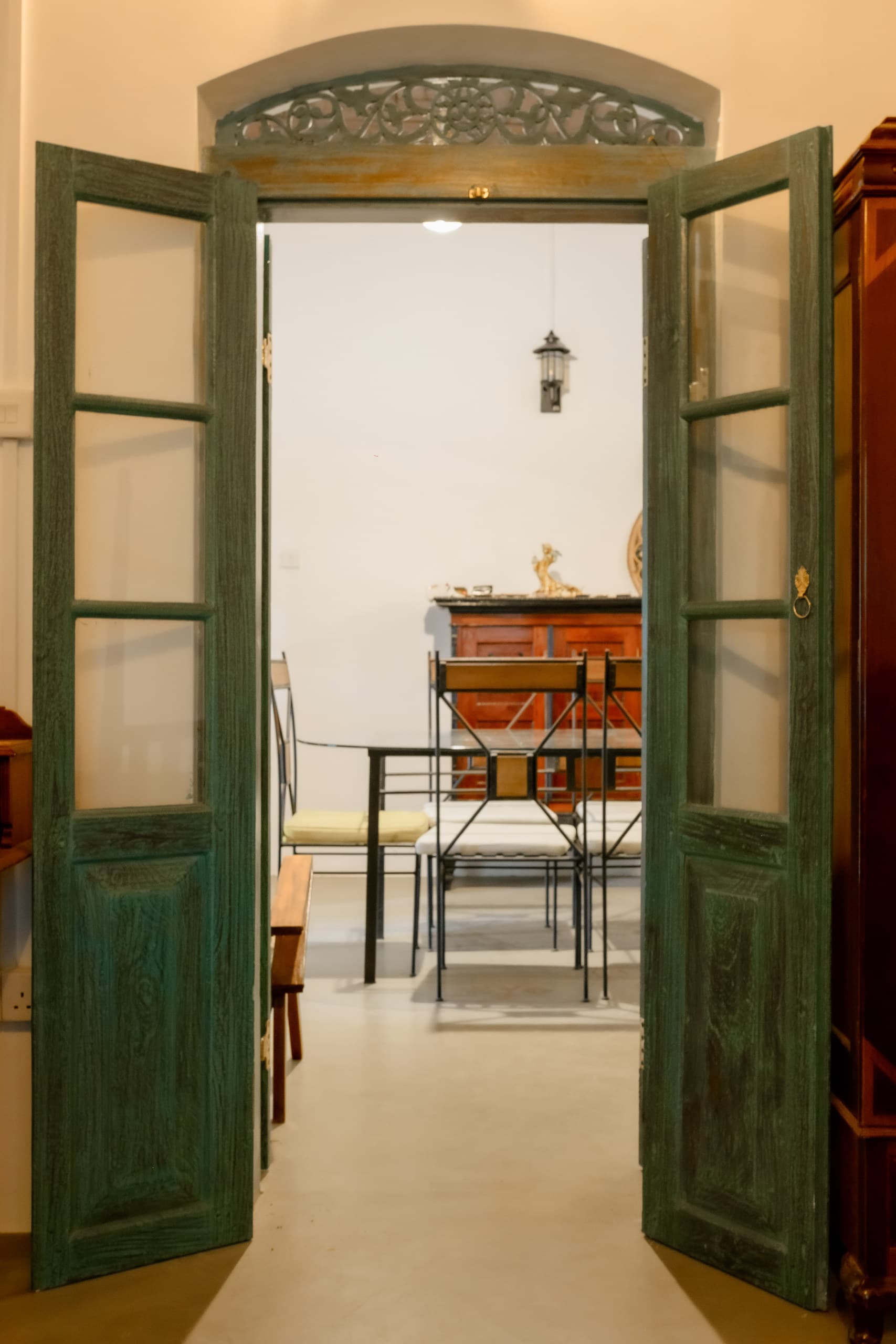 Tall green doors with carved fanlights opened onto a bright room