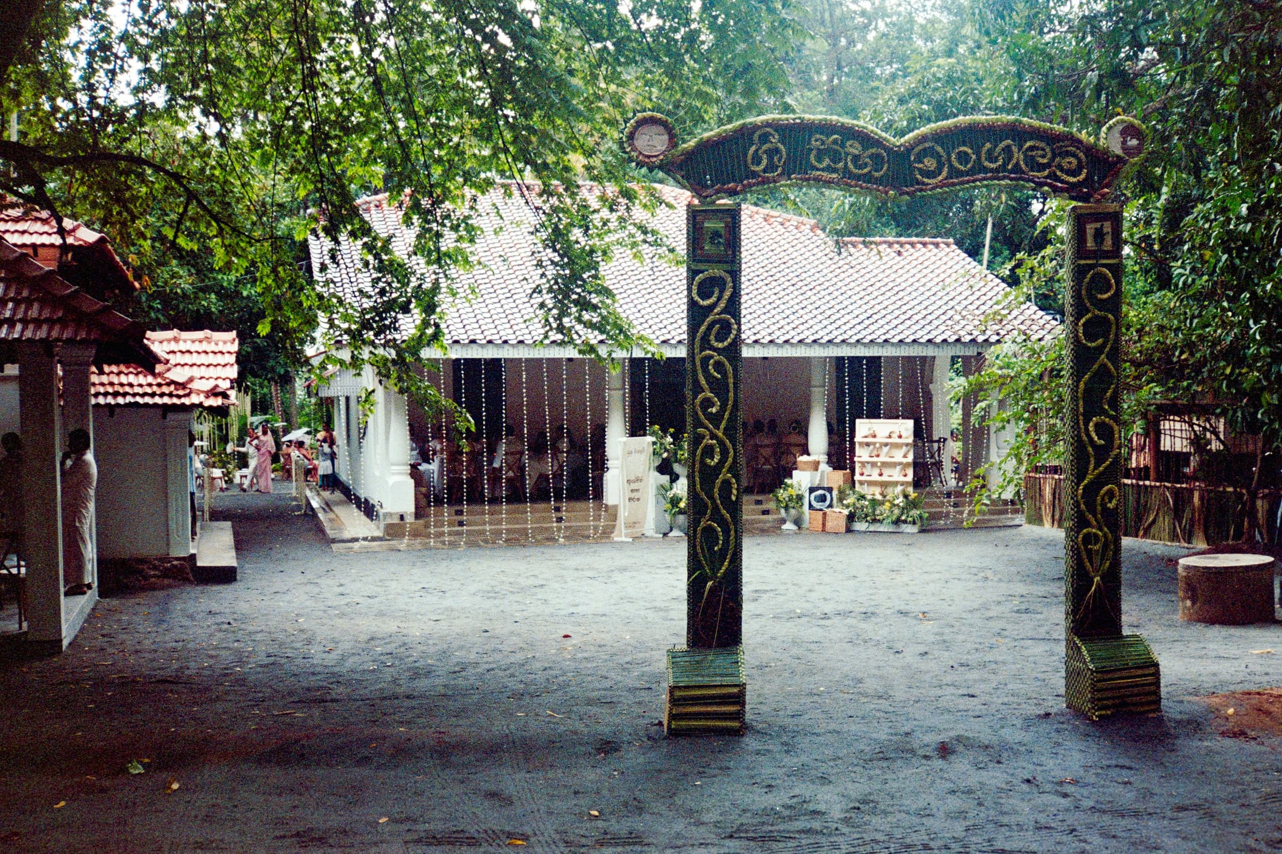 Carved wooden gateway opening onto the gravel courtyard