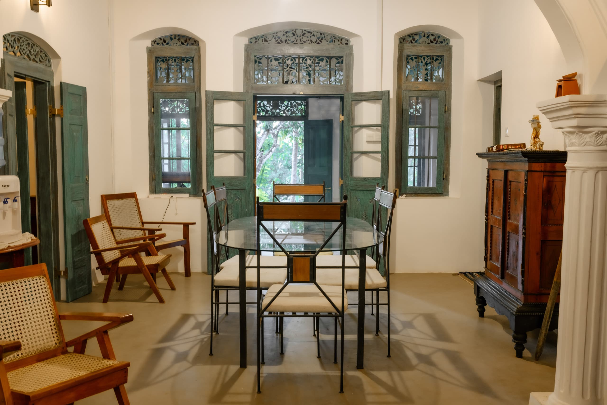 The hall with white arches, antique timber and green doors
