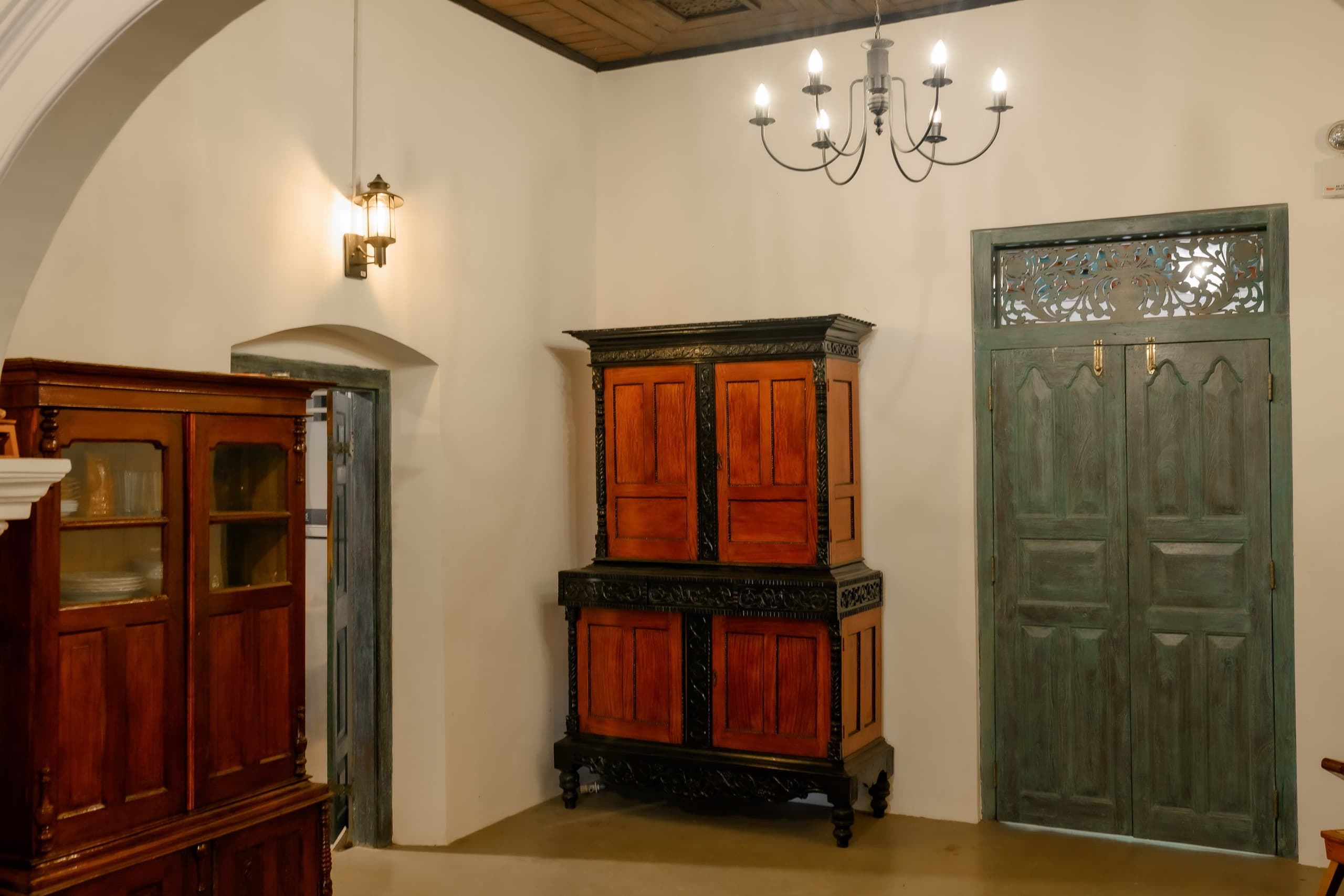Antique timber almirah beside an arched door