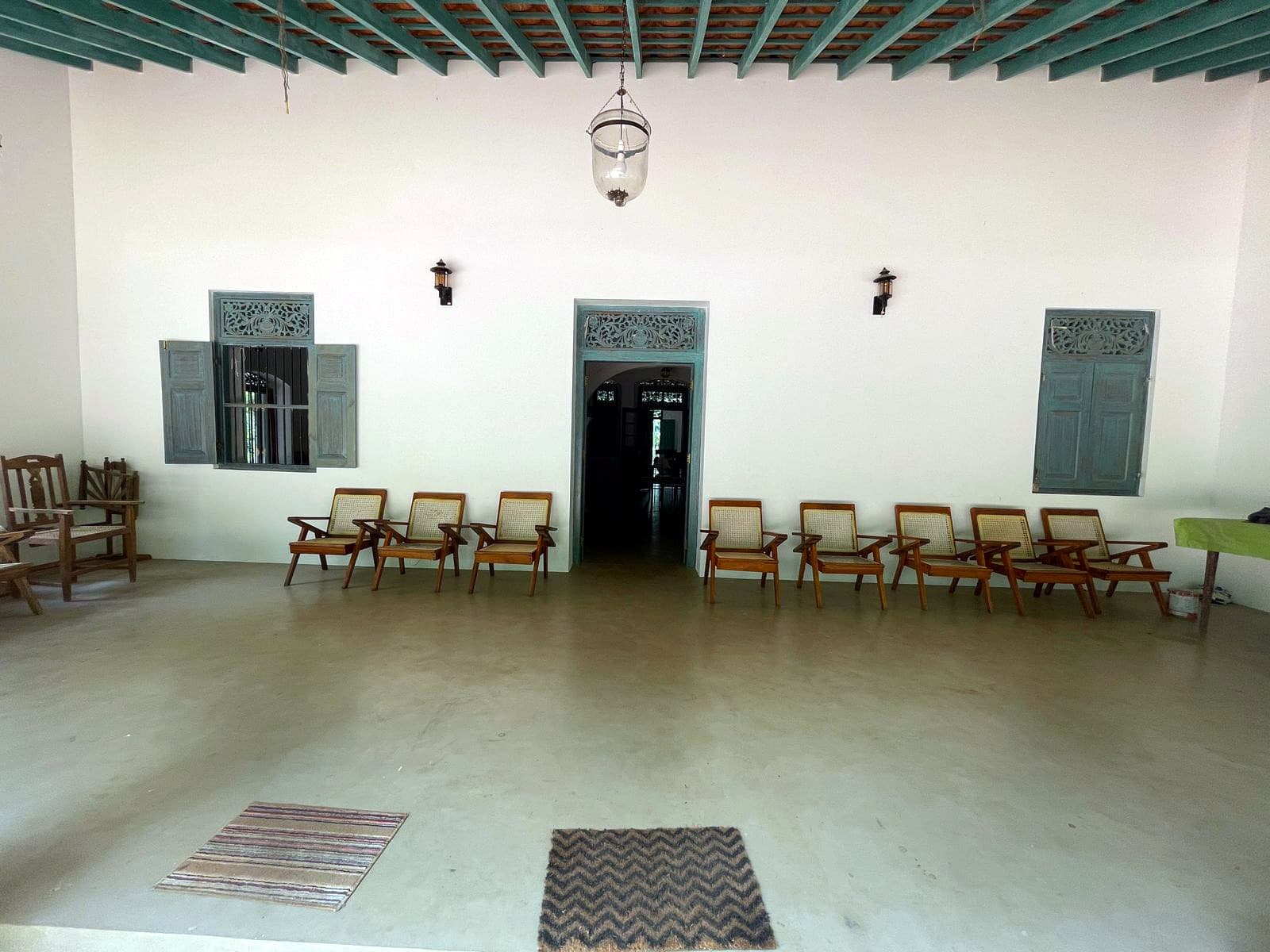 The hall with a green timber ceiling and a row of planter's chairs