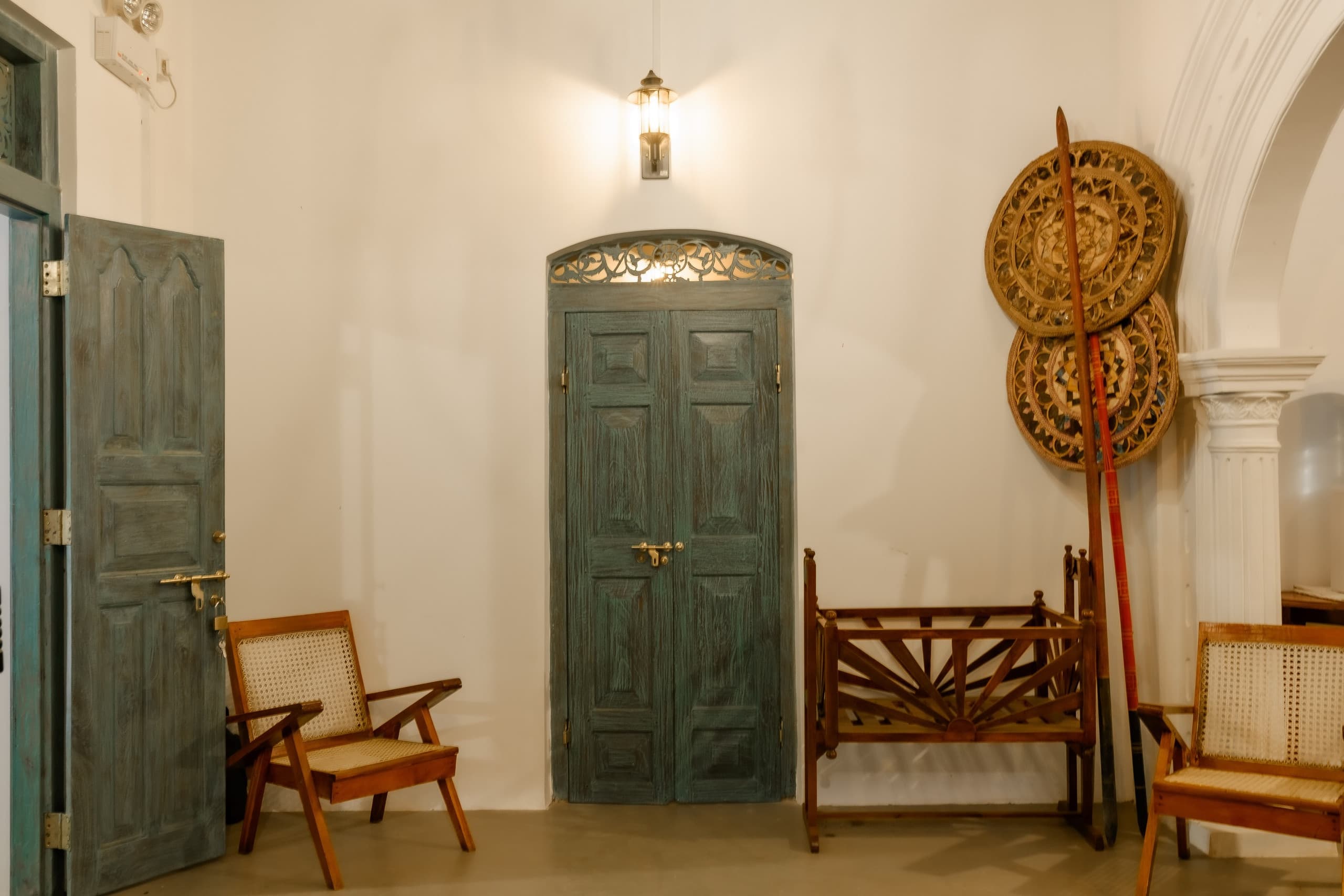 Arched green doors and carved bench in the hall